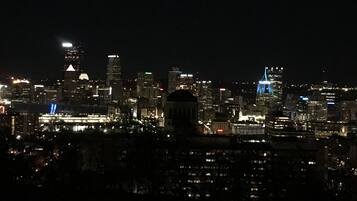 A nighttime cityscape with illuminated buildings and a prominent dome structure.
