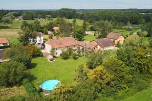 A residential area with houses, a swimming pool, and surrounding greenery.