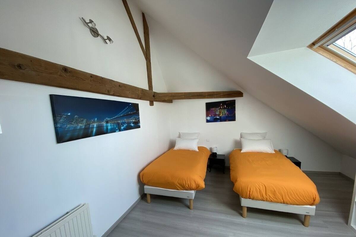Un dormitorio pequeño y moderno con dos camas, un tragaluz y fotografías de la ciudad en las paredes.