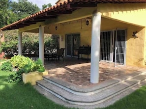 A covered patio area with a grill, outdoor seating, and a garden. - Casa Amma with garden and pool, ideal for families and friends. (Sayulita)