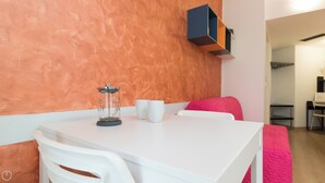 A small, modern room with a white table and chairs, a coffee maker, and two white cups. - Italianway Easy - Copernico 63 (Milan)