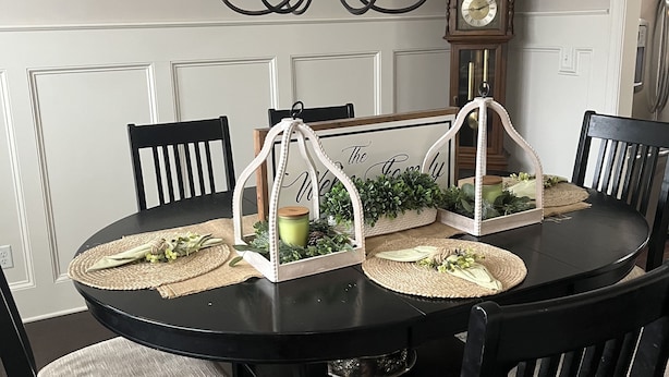 Una mesa de comedor con una araña, rodeada de sillas con asientos acolchados.