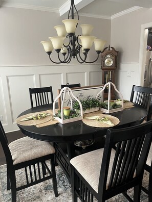 A dining table with a chandelier, surrounded by chairs with cushioned seats. - Beautiful House in Riverwood for the ANWA 2026 and Masters (Evans)