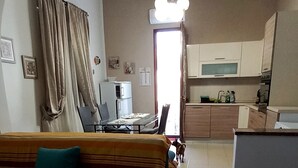 Un salon comprenant un canapé, un coin repas et une cuisine.