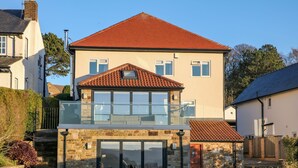 A two-story house with a balcony, stone facade, and a red-tiled roof. - Glenhurst (Dronfield)