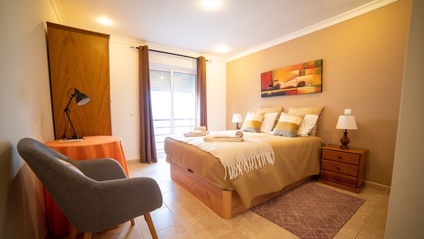 Ein Schlafzimmer mit einem Bett, Nachttischen, einem Schreibtisch und einem Stuhl.