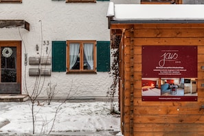 Un bâtiment en bois avec une enseigne publicitaire indiquant qu’il s’agit d’une maison d’hôtes.