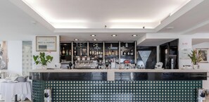 Espaço de bar com balcão, prateleiras cheias de garrafas e um letreiro emoldurado acima.