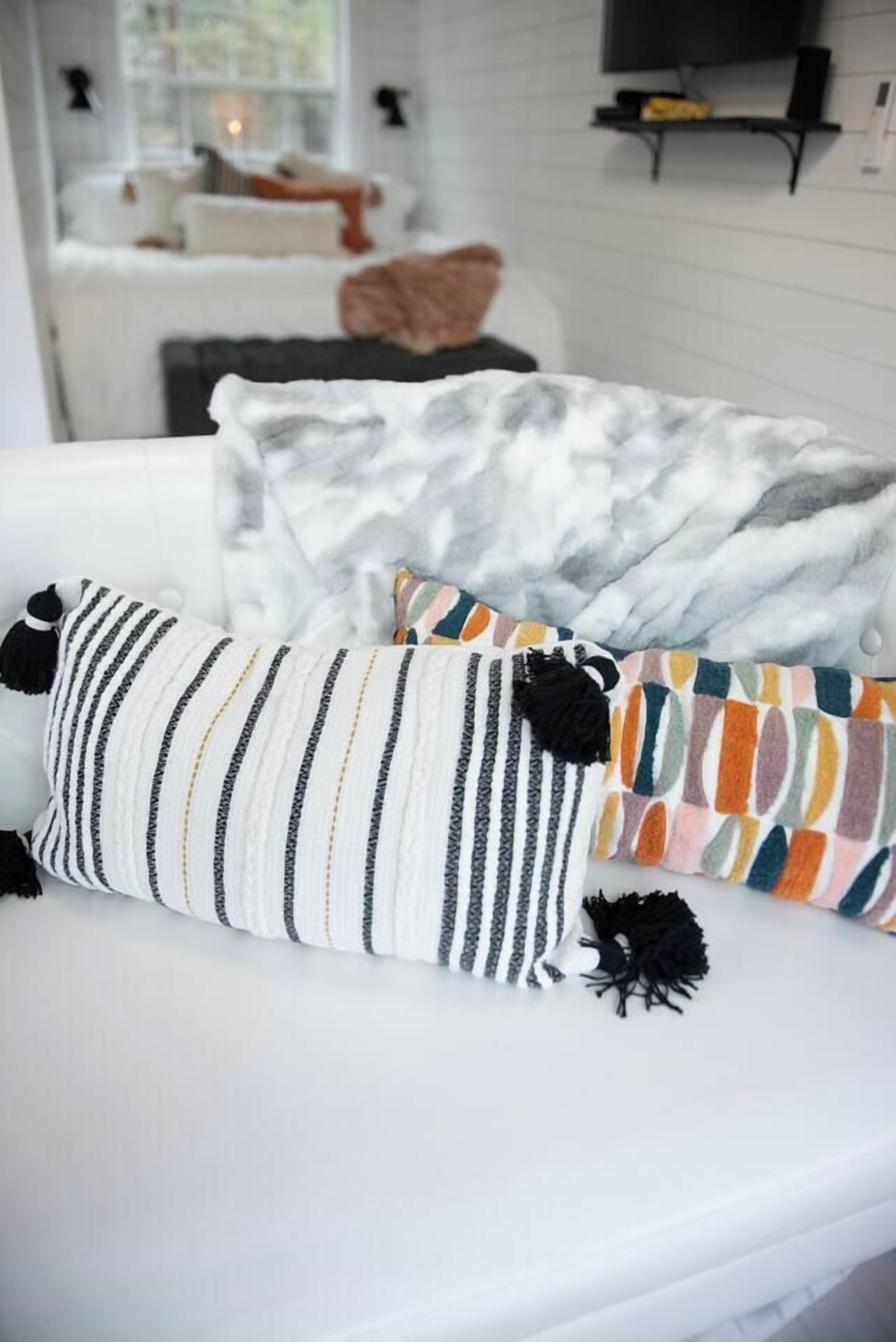 Un canapé blanc avec trois coussins dans un salon moderne.