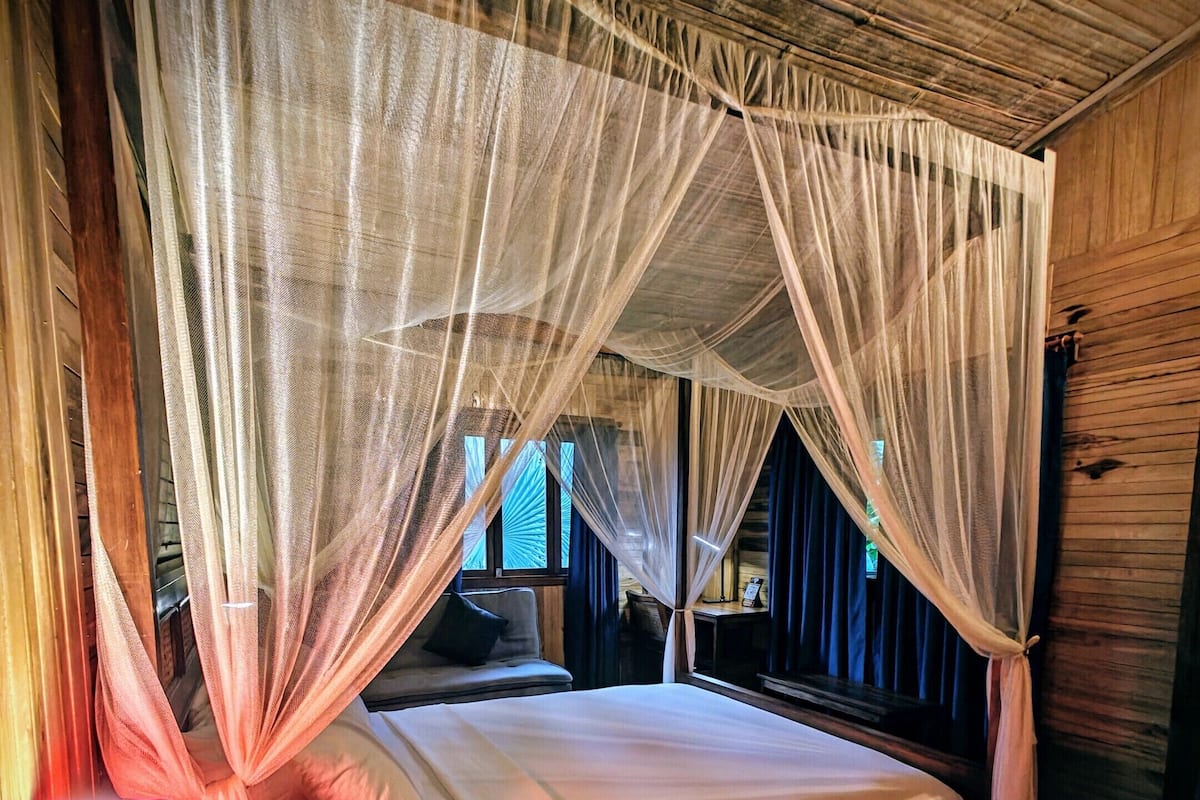 Una habitación con cama, mesita de noche y alfombra de piel.
