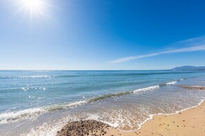 A beach with clear skies and calm waters. - Bahia de Marbella | Bright Beachside Apartment with Pool in Marbella (Marbella)