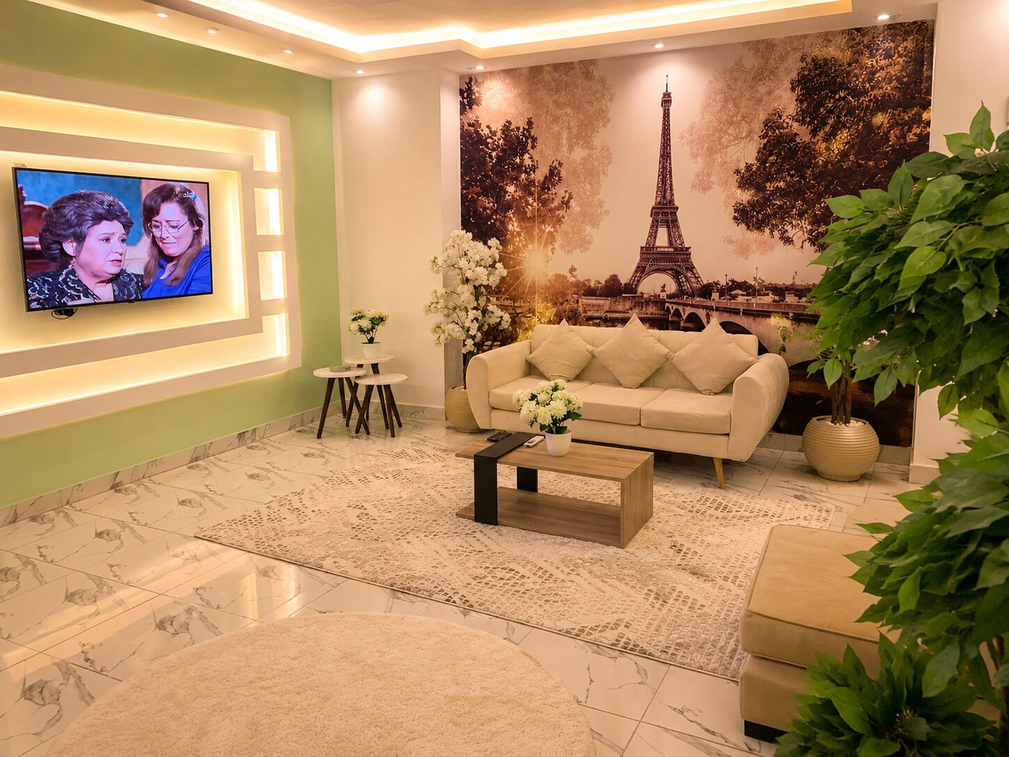 Una sala de estar con un sofá, una mesa de centro y un televisor montado en la pared.