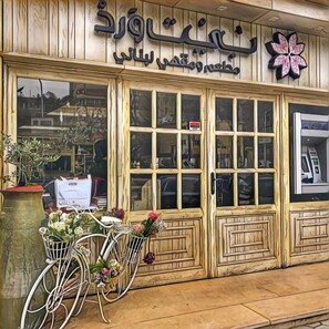 A storefront with large windows and a sign in a foreign language. - Casa Rosa - المهندسين (Giza)