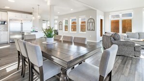 A spacious kitchen with modern appliances, a dining area with a large table and chairs, and a living area with a sofa and decorative wall art. - King bed, water and city view, gourmet kitchen, Jewel of Fairhaven  FT505 (Bellingham)