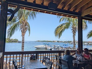A covered outdoor seating area with a view of the marina and boats.