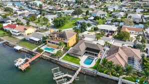 Vista aérea de una zona residencial con casas, un puerto deportivo y una piscina.