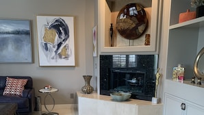 A modern living room with a fireplace, a sofa, a coffee table, and decorative items.