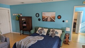 A bedroom with a bed, a dresser, a chair, and a painting on the wall. - Lovely Guest Cottage min from Perdido Key Beaches (Pensacola)