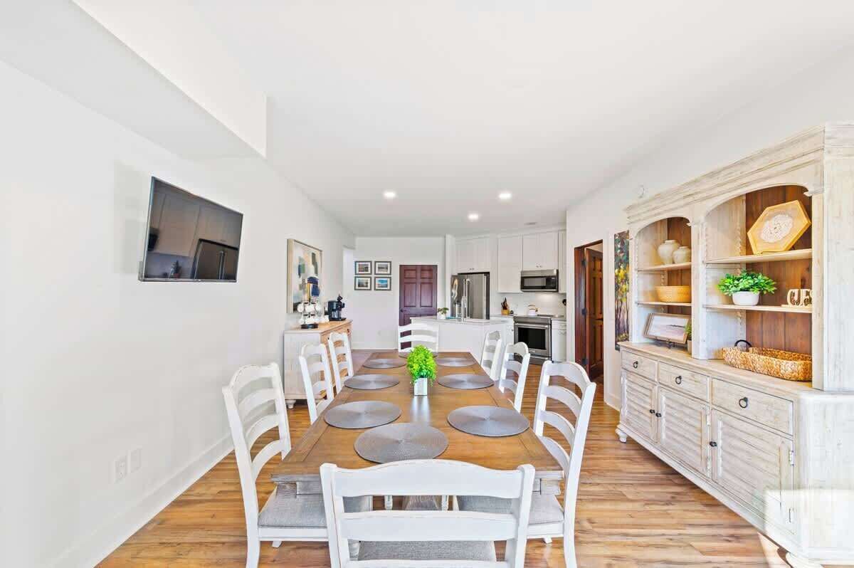 A modern kitchen with white cabinets, a built-in oven, and a microwave.