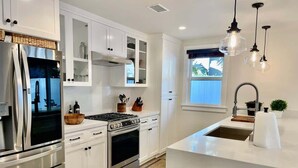 Una cucina moderna con elettrodomestici in acciaio inossidabile, mobili bianchi e forno integrato.