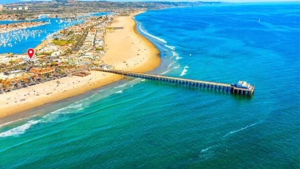 Una città costiera con spiaggia, molo e un porto turistico.