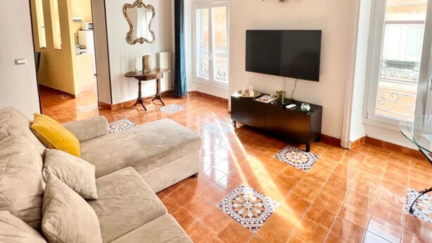 A spacious living room with a large sofa, a TV mounted on the wall, and a decorative mirror. - 90 m2 apartment in the heart of Rome, 10 meters from the Pantheon (Roma)