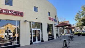 Un restaurant Chipotle doté d’une grande baie vitrée et d’une enseigne indiquant « Asian Kitchen ».