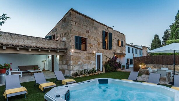 A stone building with a hot tub, outdoor seating, and a well-maintained lawn. - Villa with jacuzzy in Pollensa town (Pollensa / Pollença)