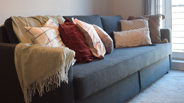 A modern living room with a grey sofa, a macrame wall hanging, and a large window with curtains. - Cozy Dublin City Apt near Guinness Storehouse and Temple Bar (Dublin)