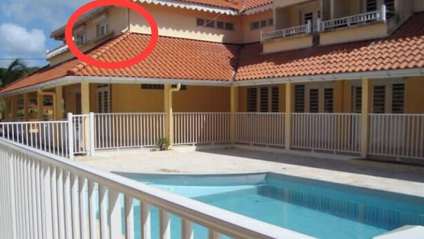 A multi-story building with a swimming pool, white railings, and a red-tiled roof. - Anse à l'âne apartment  (Les Trois-Îlets)