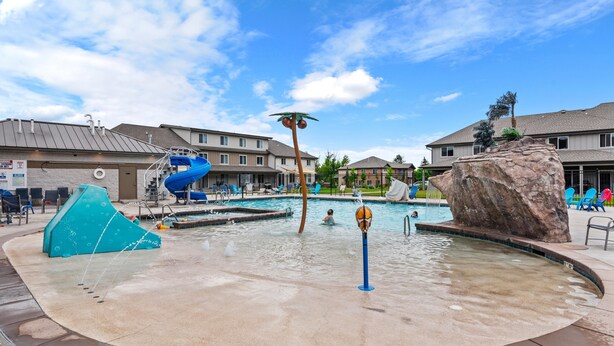 A swimming pool area with a water slide, a rock feature, and a basketball hoop. - Townhome 47, 3 Bed-12 Guests with indoor/Outdoor pools+Rec Center at Waterdance (Garden City)