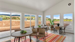 A spacious indoor area with large windows offering views of a landscaped outdoor area. - Townhome 47, 3 Bed-12 Guests with indoor/Outdoor pools+Rec Center at Waterdance (Garden City)