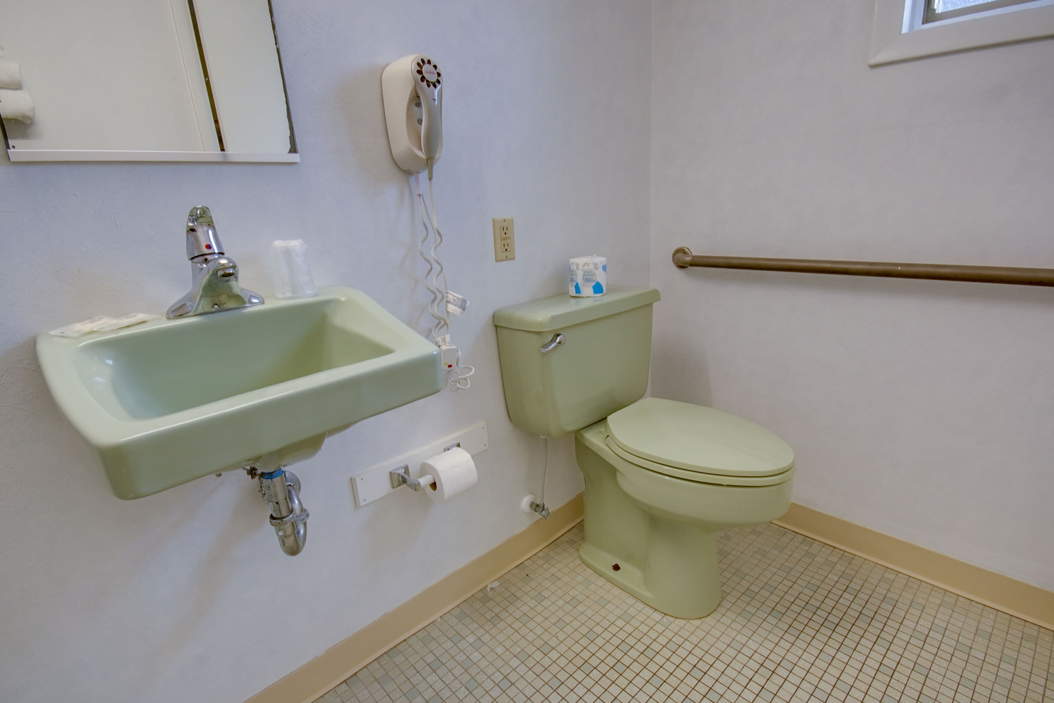 Ein Badezimmer mit Waschbecken, Toilette und Handtrockner.