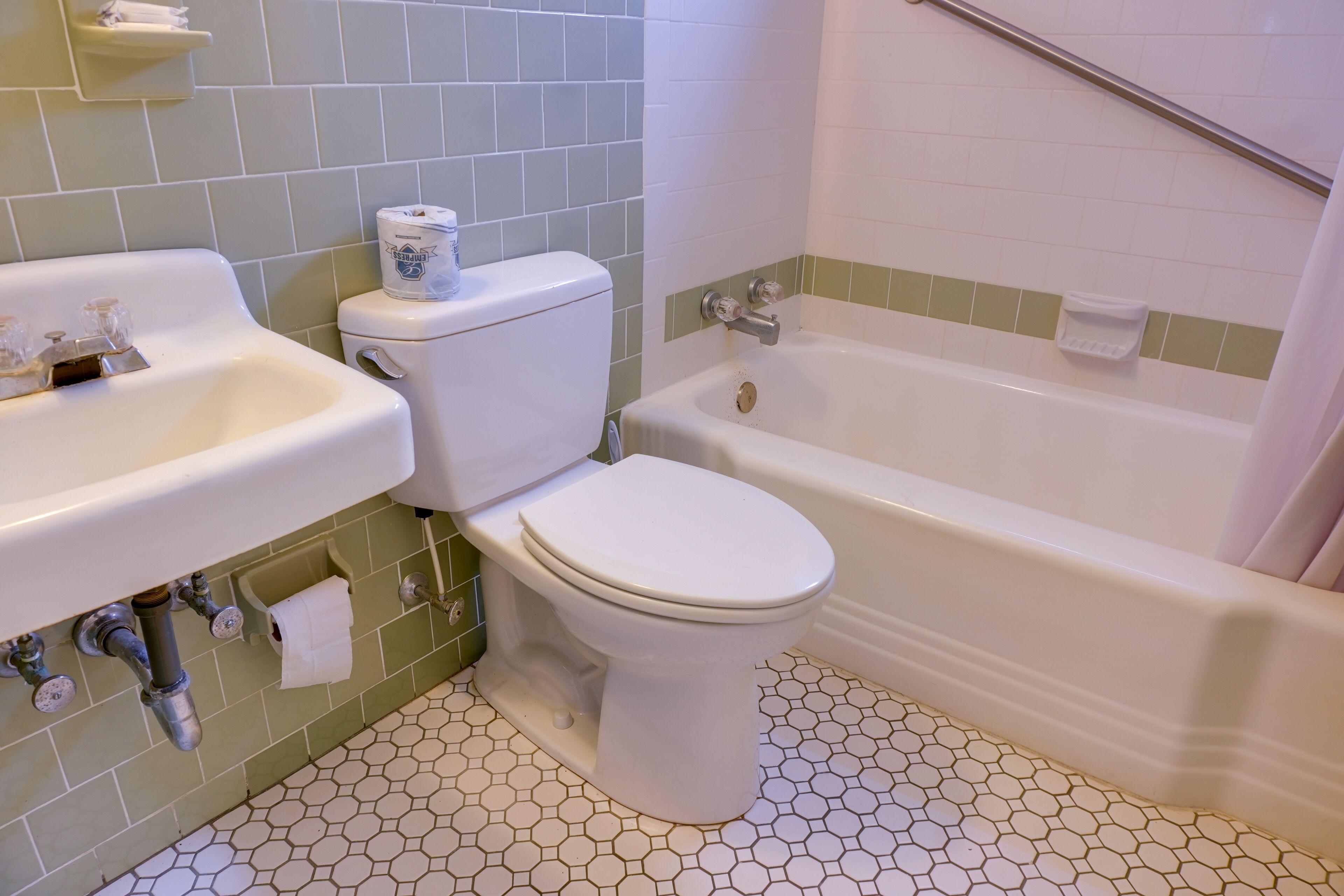 A bathroom with a toilet, sink, and bathtub.