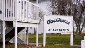 A sign for Ocean Terrace Apartments with a contact number. - Ocean Terrace Family Apartments (Ocean City)