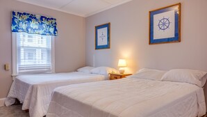 A room with two single beds, a window with blinds, a wall-mounted compass picture, and a bedside lamp. - Ocean Terrace Family Apartments (Ocean City)