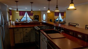 A kitchen with a central island, stainless steel appliances, and pendant lighting.