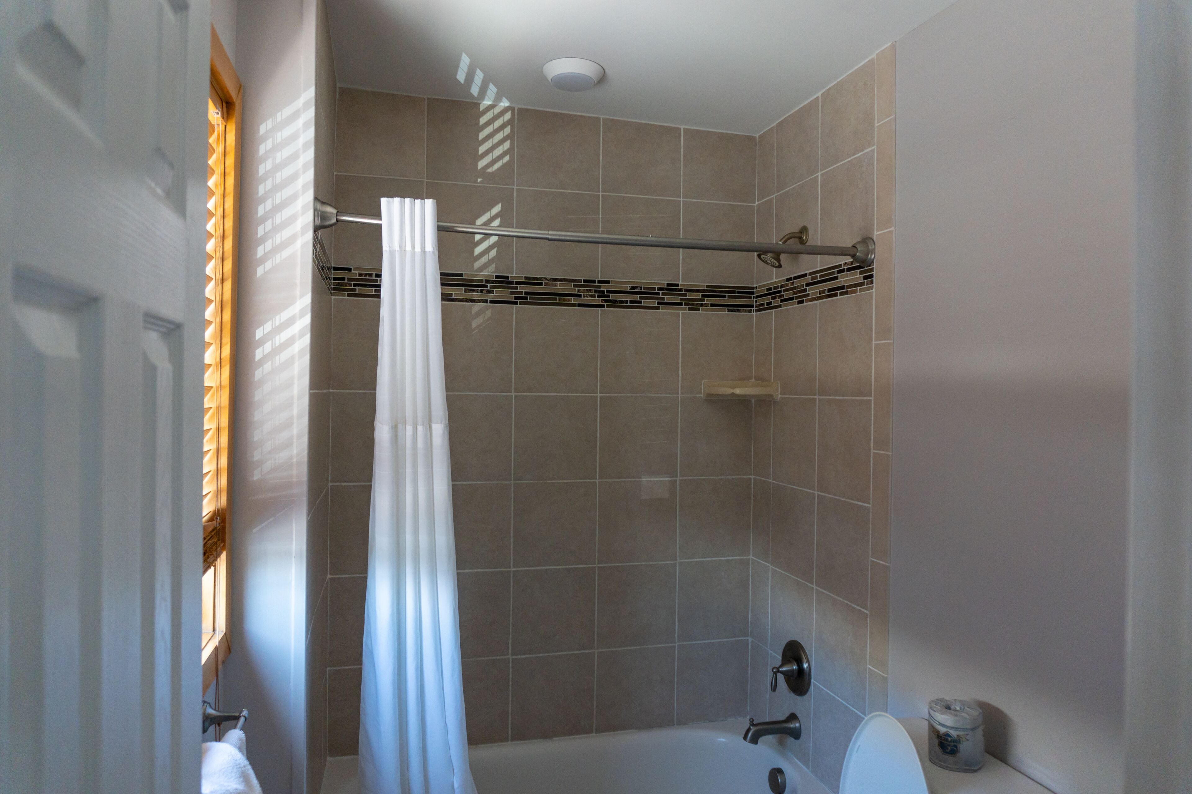 A bathroom with a bathtub, shower, and toilet.