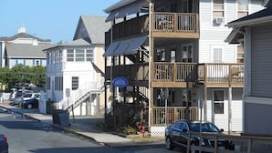 A two-story hotel with a balcony on the second floor, a visible entrance, and a sign indicating it is a hotel.