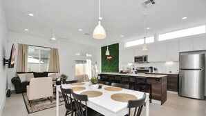 A modern kitchen with a central island, white cabinets, and stainless steel appliances. - Modern Townhome-5 minutes to Downtown-Sleeps 9 Comfortably-King Suite (Houston)