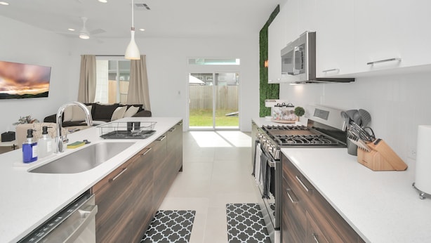 A modern kitchen with a central island, stainless steel appliances, and a large window. - Modern Townhome-5 minutes to Downtown-Sleeps 9 Comfortably-King Suite (Houston)