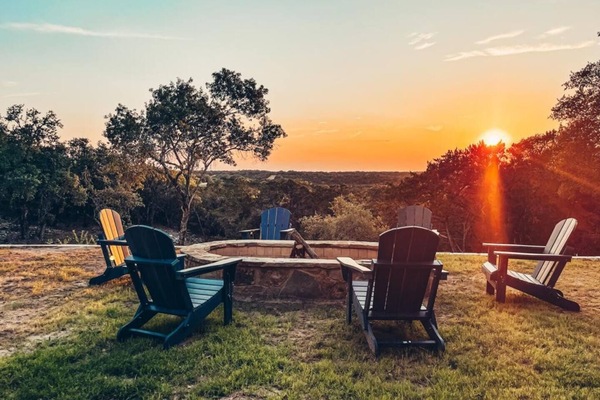 The backyard offers a large fire pit with comfy Adirondack chairs for cozy evenings by the fire. Dive into the pool or relax in the hot tub while taking in the breathtaking views of the Pedernales River Valley.