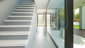 A modern staircase with white steps leading to a glass door. - Captivating Panoramic Sea View, Unique Architecture, 10 Minutes from Beach




 (Σκουλούφια)