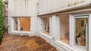 A building with large windows, a wooden deck, and a small garden area. - Underground Batalha Studios - A (Oporto)