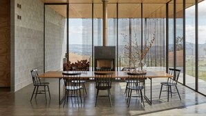 Een moderne eetruimte met een grote tafel, stoelen en een open haard.