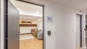 A modern apartment with a wooden floor, a sofa, a small table, and a wall-mounted air conditioner. - Underground Batalha Studios - D (Oporto)