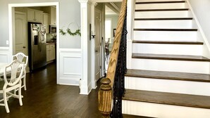 A staircase with wooden steps and a black handrail, leading to a landing with a white door. - 2026 Master’s Rental, 3 Story with pool—Just 12 Miles from the Augusta National (Evans)