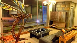 A modern lounge with a glass sculpture, a fireplace, and a seating area.