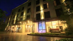 A multi-story hotel with a modern facade, large windows, and a well-lit entrance.