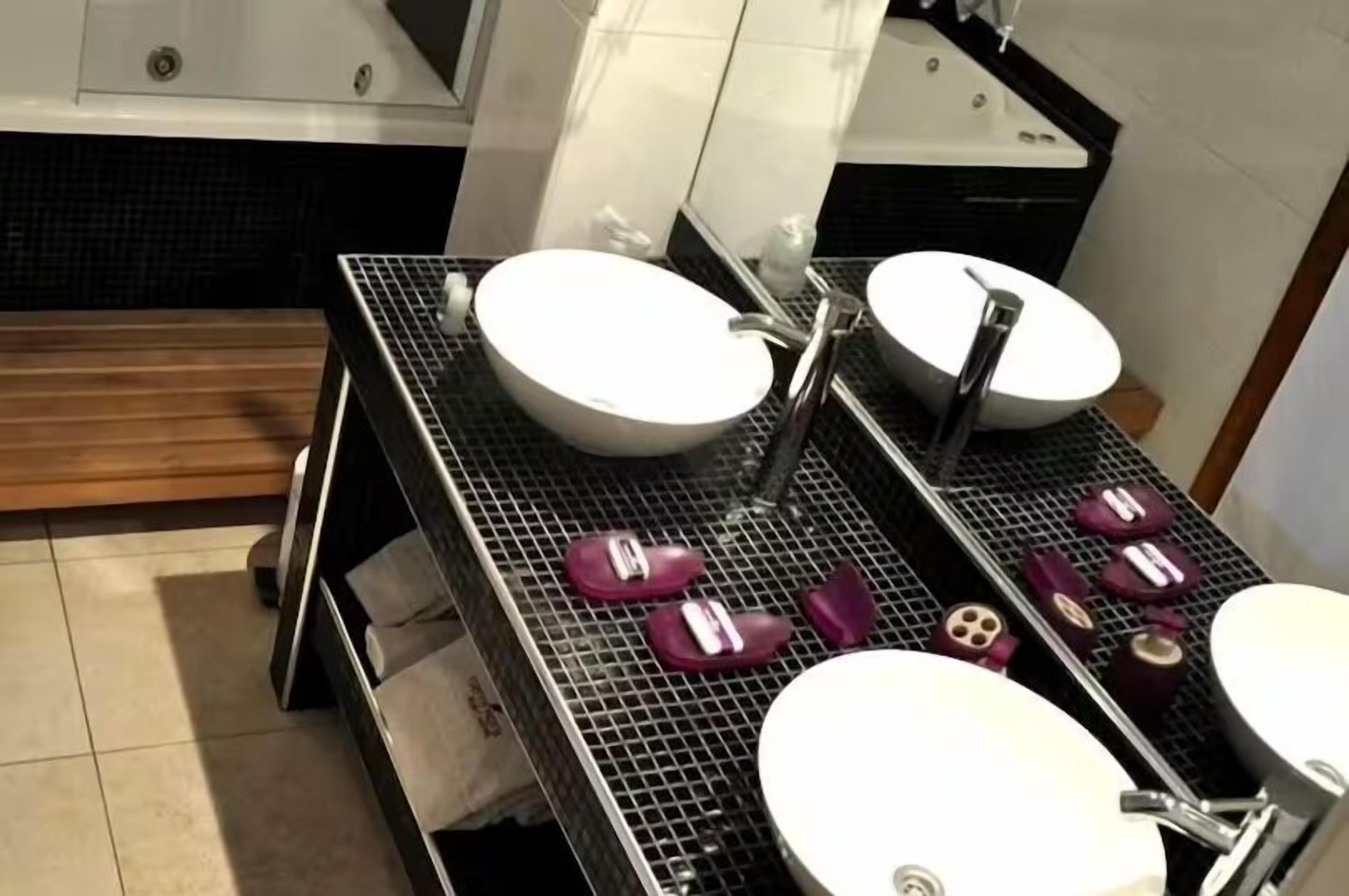 Une salle de bain avec deux lavabos, une douche et un miroir.